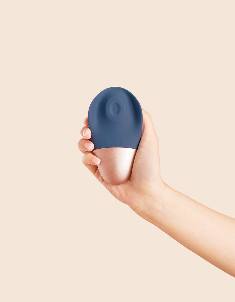 Deia's AROUSER clitoral stimulator being held in hand-showing body-facing side