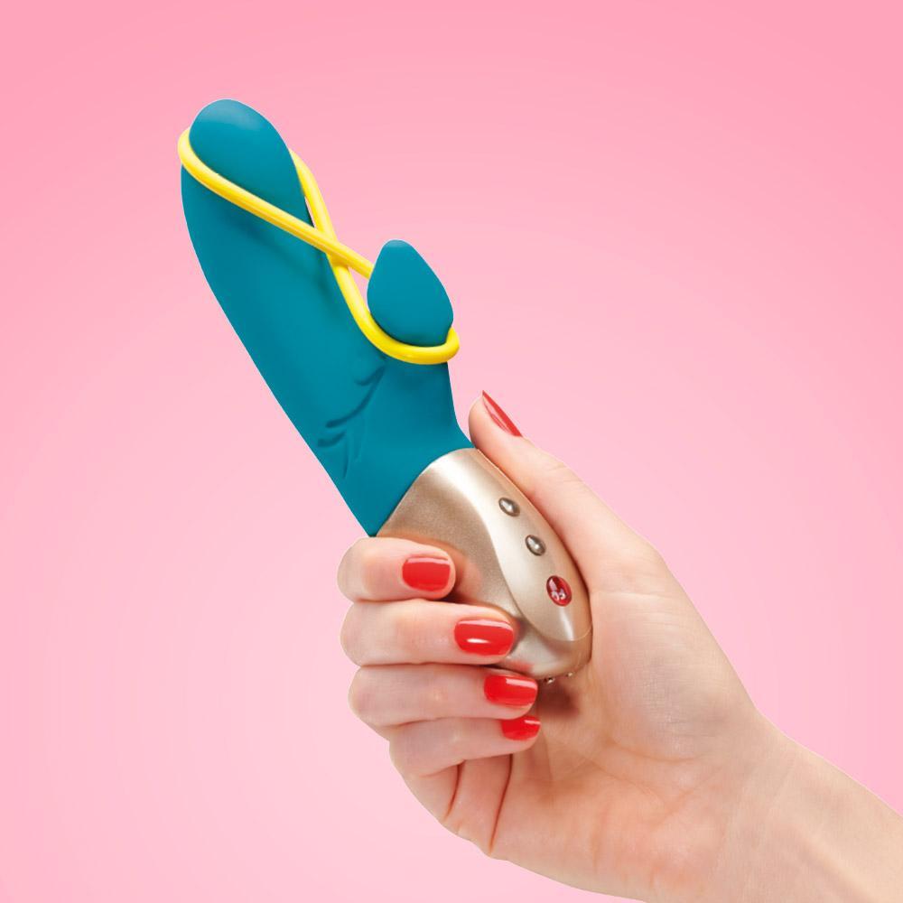 female hand holding the torquois fun factory vibrator with libia stimulator